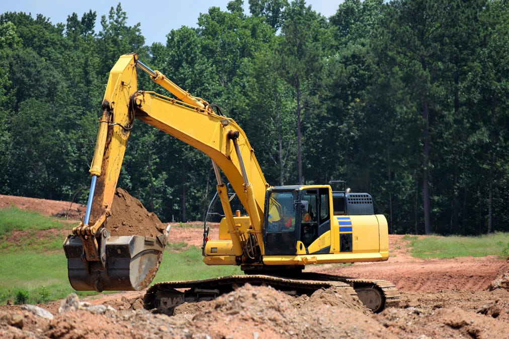 excavator digging dirt in a field